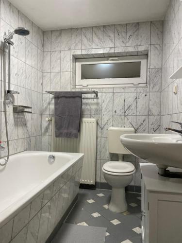a bathroom with a toilet and a tub and a sink at Gemütliches Häuschen in Schwerin