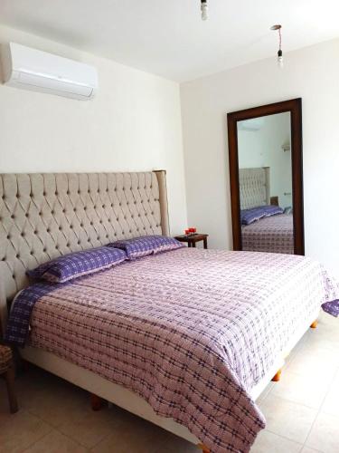 a bedroom with a bed and a mirror at Bella Casa Familiar in Cancún