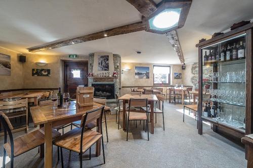 a restaurant with wooden tables and chairs and a fireplace at Alpe Rebelle in Bionaz