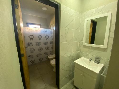 y baño con aseo, lavabo y espejo. en Aires Casas de campo en Villa Santa Cruz del Lago