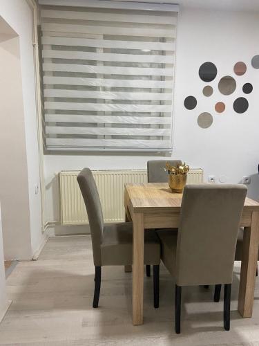 a dining room with a wooden table and chairs at Apartman Rose in Kruševac