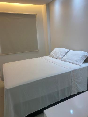 a bed with white sheets and pillows in a room at Reserva das praias in Manaus