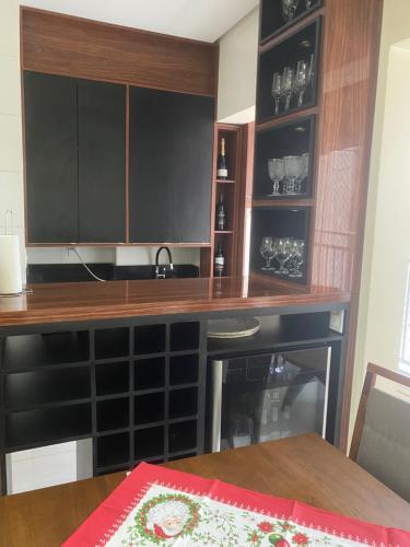 a kitchen with a table and a counter with black cabinets at Reserva das praias in Manaus