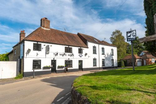a white building on the corner of a street at The White Horse, Rogate in Petersfield
