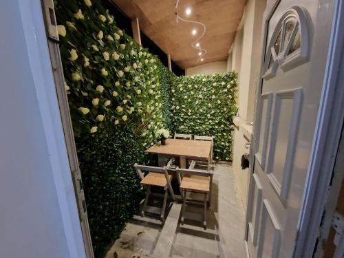 a table and chairs in a room with a wall of roses at 31 London Road Liverpool Studio Sleeps 4 in Liverpool