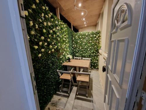 a table and chairs in a room with a wall of roses at 31 London Road Liverpool Sleeps 4 in Liverpool