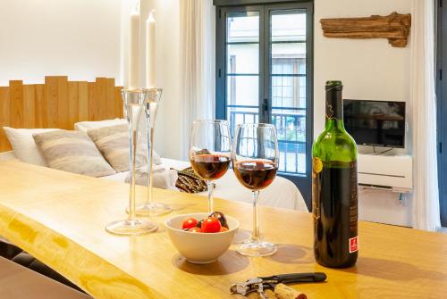 einen Tisch mit Weingläsern und eine Flasche Wein in der Unterkunft Reino de Asturias, WIFI, VUT155 in Oviedo