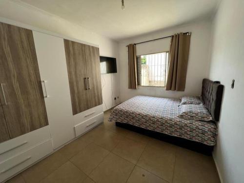 Schlafzimmer mit einem Bett und einem Fenster in der Unterkunft ap centro campinas in Campinas