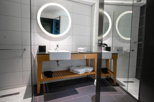 uma casa de banho com um lavatório e 2 espelhos em Hampton By Hilton Bariloche em San Carlos de Bariloche