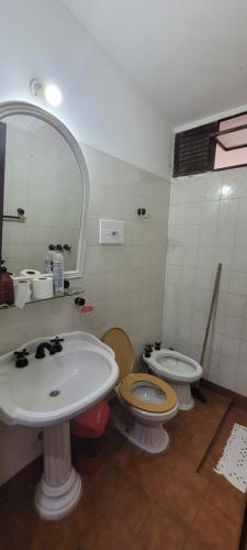 ein Badezimmer mit 2 WCs, einem Waschbecken und einem Spiegel in der Unterkunft A Lau' De Los Álamos in Humahuaca