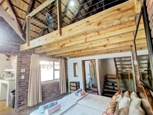 a room with a bed and a wooden ceiling at Athule Inn Marloth - Units in Marloth Park
