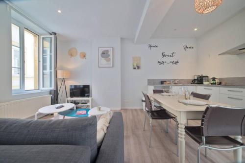 un salon avec un canapé et une table avec des chaises dans l'établissement L'appartement du poète - 4P - Hyper centre, à Metz