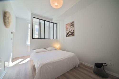 biała sypialnia z łóżkiem i oknem w obiekcie L'appartement du poète - 4P - Hyper centre w Metz