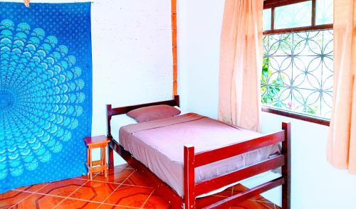 1 dormitorio con cama y ventana. en Mambo Ecohostal, en San Lorenzo
