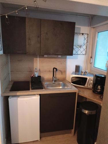 a small kitchen with a sink and a microwave at Superbe vue mer... Au calme in Ault