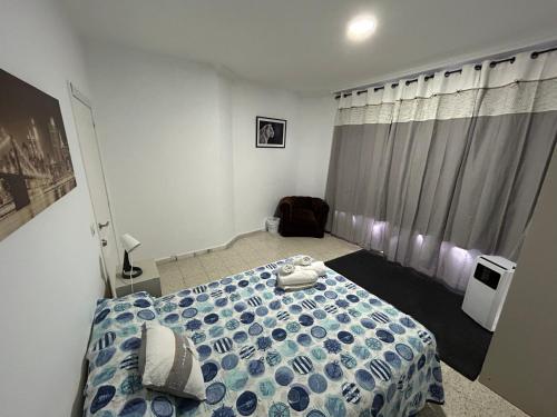1 dormitorio con 1 cama con edredón azul y blanco en Malaguetor Home, en Málaga