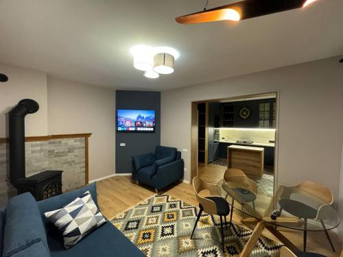 sala de estar con sofá azul y chimenea en Apartments Mandry, en Yaremche