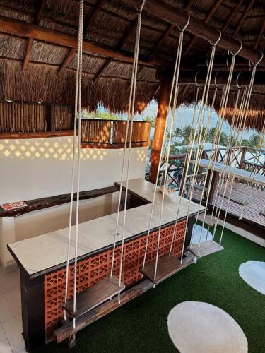 a swing in a house with a green floor at Suites Valentina in Puerto Morelos