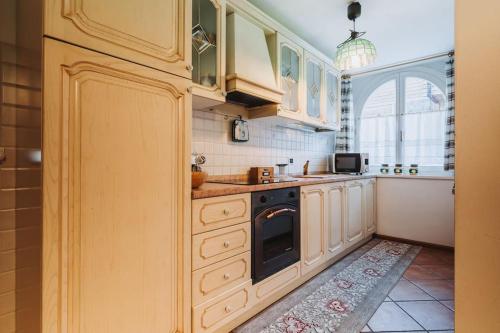 a kitchen with white cabinets and a stove top oven at Il Rifugio di Dante - 10 Minuti dagli Impianti, Deposito e Parcheggio Privato in Moena