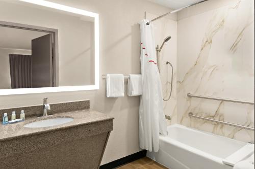 W łazience znajduje się umywalka, wanna i lustro. w obiekcie Quality Inn & Suites w mieście Weatherford
