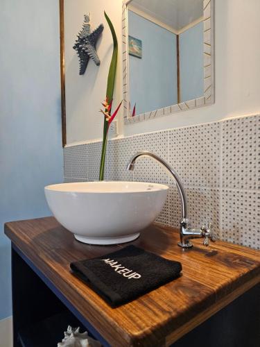 a bathroom counter with a sink and a flower at Casa Pelicano in Bocas Town