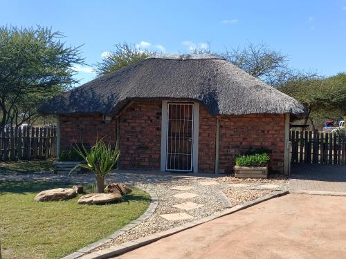 a small brick building with a straw roof at Unique Overnight Polokwane in Polokwane