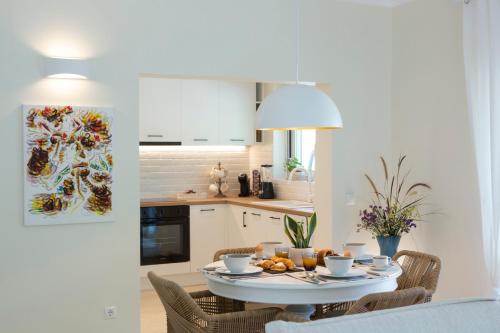 a white kitchen with a table and chairs at Villa Kallisti - private villa with hot tub, large garden, close to the beach in Ayía Varvára