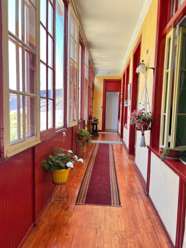 an empty hallway of a building with windows and a rug at El Mirador De Valparaiso in Valparaíso