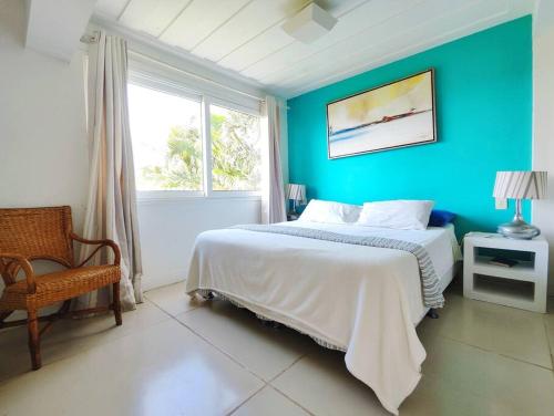 ブジオスにあるCasa maravilhosa com vista para o mar 50mt da Orlaの青いベッドルーム(ベッド1台、窓付)
