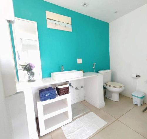 ブジオスにあるCasa maravilhosa com vista para o mar 50mt da Orlaの青い壁のバスルーム(白い洗面台付)