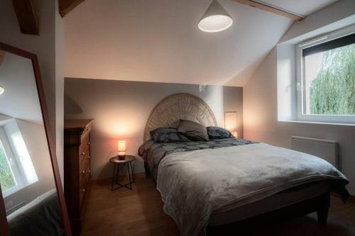 une chambre avec un lit et une fenêtre dans l'établissement Gîte Sous le Verger, à Songeson