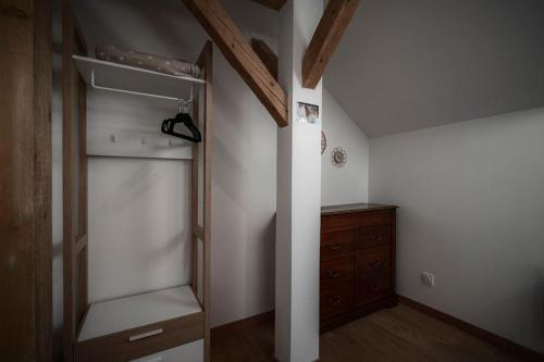 Cette chambre comprend un placard avec une commode en bois. dans l'établissement Gîte Sous le Verger, à Songeson