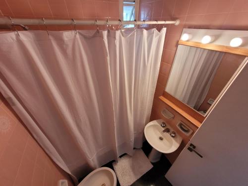 a bathroom with a white shower curtain and a sink at Pampa, Mayo home in Buenos Aires