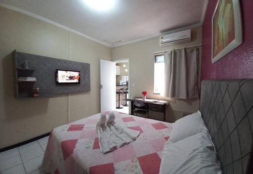 a bedroom with a bed and a tv on the wall at Apartamento Mobiliado temporada in Aracaju