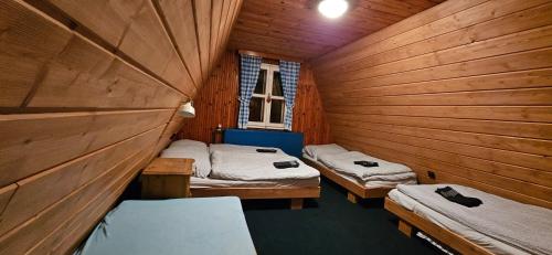 two twin beds in a room with wooden walls at Chata Čenkovice in Čenkovice