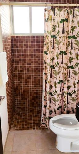 a bathroom with a shower curtain and a toilet at Bella Casa Familiar in Cancún