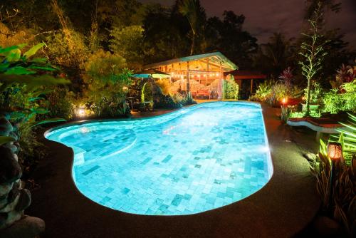 una piscina por la noche con una casa en Casitas Del Rio Riverfront Jungle Beach Vacation, en Uvita