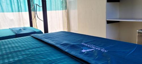 a bed with a blue comforter in a room at Cabaña El Faro in Tubará