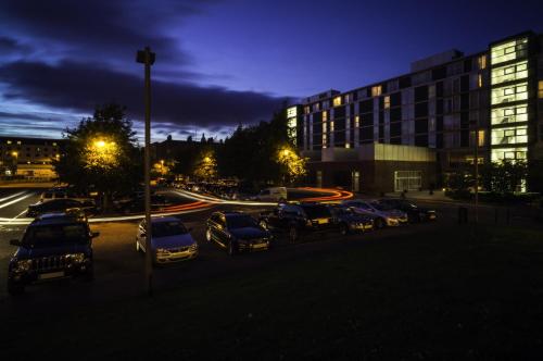 a parking lot with cars parked in front of a building at Apex City Quay Hotel & Spa in Dundee