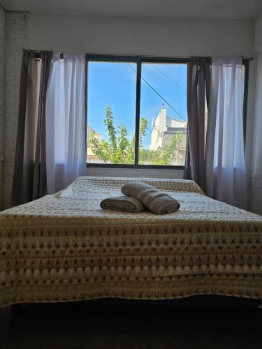 una cama con dos toallas delante de una ventana en Estrella del puerto en Mar del Plata