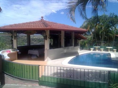 a gazebo with a swimming pool next to a house at Garita Inn Delux in La Garita