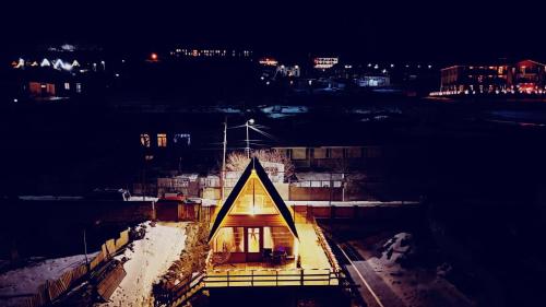 a building with a triangle on it at night at Cottage Nishi in Stepantsminda