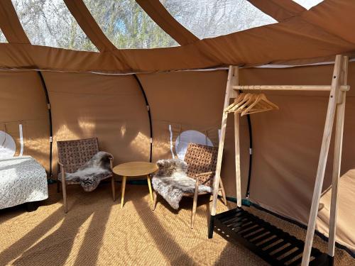 a room with a bed and chairs in a tent at Romantik Luxus Glamping 2 in Idestrup