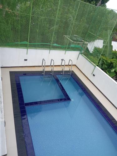a swimming pool in a building with blue water at VILLA AAA WELIGAMA in Weligama
