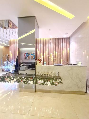 eine Lobby eines Hotels mit einer Theke mit Blumen in der Unterkunft Spring Residences 1 Bedroom Deluxe Near Airport in Manila