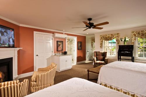 a bedroom with two beds and a fireplace at The Winstead Inn in Harwich