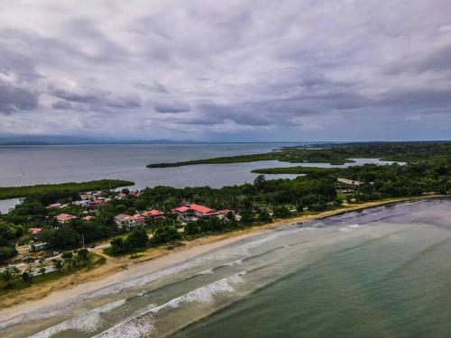 een luchtzicht op een strand met huizen en de oceaan bij Seaside Apartment near Bocas Town in Istmito