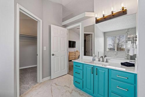 baño con armarios azules y lavamanos en Large Serene Farmington Retreat, en Farmington