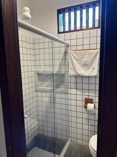 uma casa de banho com uma cabina de duche em vidro e um WC. em Chalé Casa Vitoria - Quarto Inferior em Trancoso