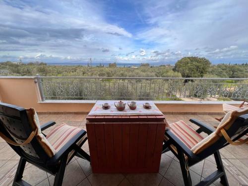 a patio with two chairs and a table on a balcony at VS Villa Killini in Káto Panayía